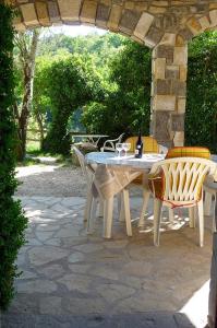 a table and chairs on a stone patio at Gîtes du Domaine de Serre Long in Saint-Maurice-dʼIbie