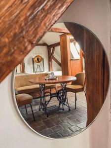 een ronde spiegel in een kamer met een tafel en stoelen bij Wellness Pension Ametyst in Český Krumlov