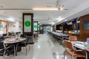 a restaurant with tables and chairs and a bar at Treebo Trend South Avenue 700 Mts From Promenade Beach in Puducherry