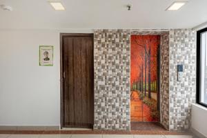 a door in a room with a painting on the wall at Treebo South Avenue, 700 Mts From Promenade Beach in Puducherry