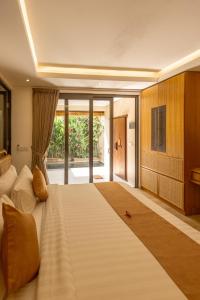 a large bedroom with a large bed and a television at Lasanti Villas Seminyak in Seminyak