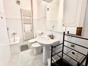 een witte badkamer met een wastafel en een toilet bij Dimora D'artista con vista in Cairo Montenotte