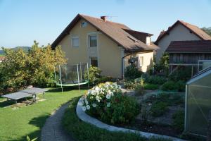 ein Haus mit einem Garten und einer Bank im Hof in der Unterkunft Ferienwohnung Familie Hartinger in Riegersburg
