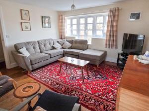 a living room with a couch and a red rug at Relaxing townhouse in the heart of Bridport in Bridport