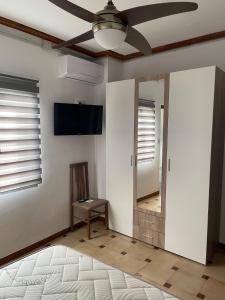un soggiorno con ventilatore a soffitto e specchio di APARTAMENTOS LEONOR a Baeza