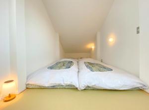 YS Building 3F - Vacation STAY 31281v في كاكِغو: سرير مع وسادتين في غرفة صغيرة