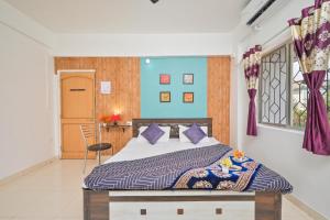 a bedroom with a bed with blue walls and a window at EMPYREAN STAY II 2BHK II AC II POOL II SANAM VILLA ll in Lonavala