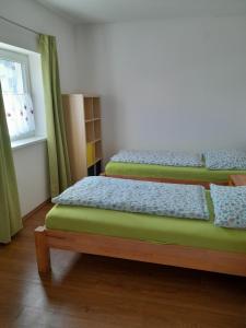 two twin beds in a room with a window at Ferienhaus Weißbacher Wien in Vienna