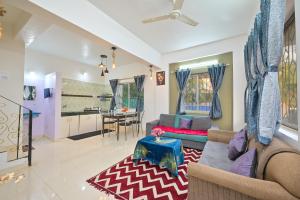 a living room with a couch and a table at EMPYREAN STAY II 2BHK II AC II POOL II SANAM VILLA ll in Lonavala