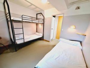 sypialnia z 2 łóżkami piętrowymi i lustrem w obiekcie CIS de Champagne - Ethic Etapes w mieście Reims