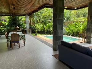 un patio con mesa, sillas y piscina en Pandan Villas, El Nido en El Nido