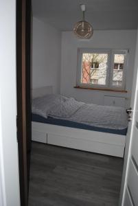 Habitación pequeña con cama y ventana en Apartament Bukovska en Poznan