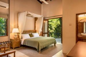 a bedroom with a bed and a large window at The Weir House in Ulapane