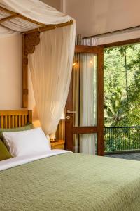 a bedroom with a bed and a large window at The Weir House in Ulapane