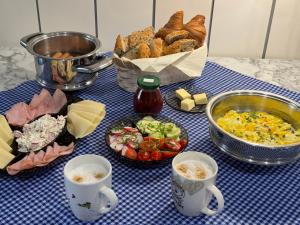 una mesa cubierta con platos de comida y tazas de café en Perfect Remote-Workplace in Sunny Apartment, en Myślenice