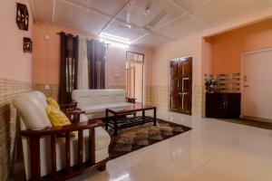 Collection O Trinayan Associates في ديبروجاره: غرفة معيشة مع أريكة وكرسي