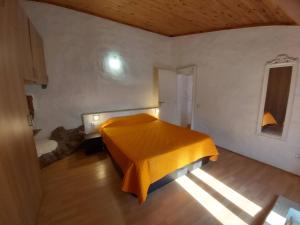 a bedroom with a bed with a yellow blanket at Bela Vista House - Quinta amoreira in Benafim
