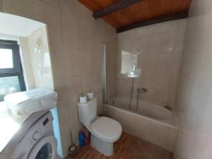 a bathroom with a toilet and a shower and a sink at Bela Vista House - Quinta amoreira in Benafim