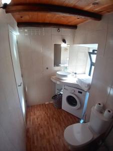 a bathroom with a toilet and a sink and a washing machine at Bela Vista House - Quinta amoreira in Benafim