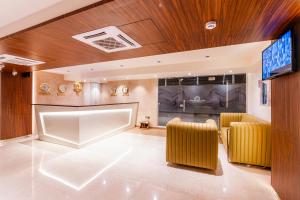 a lobby with two yellow chairs and a flat screen tv at Treebo Tryst Heritage Grand - Thane in Mumbai