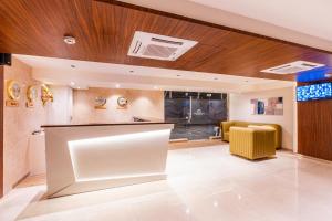 a lobby with a white counter and wooden ceilings at Treebo Tryst Heritage Grand - Thane in Mumbai