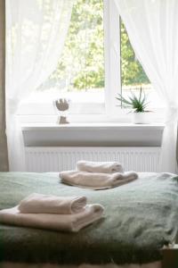 Dos toallas en una cama frente a una ventana en Hotel "Senleja", en Sigulda