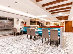 un restaurante con una mesa larga y sillas en Treebo Tryst Heritage Grand - Thane, en Bombay