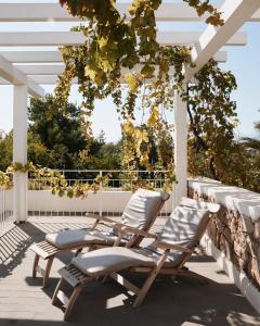 two lounge chairs on a deck with a pergola at Lanthia Resort in Santa Maria Navarrese