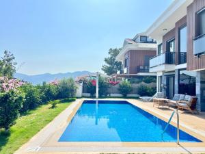 een zwembad in de achtertuin van een huis bij VİLLA NEST Largely Designed Private Villa with Pool & Garden in Göcek in Göcek