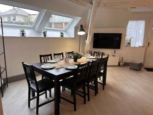 a dining room with a table with chairs and a television at Le Clos de Clara in Pierry