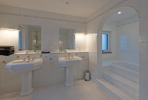 La salle de bains blanche est pourvue de 2 lavabos et d'une baignoire. dans l'établissement Casa Lorsch 2, à Lorsch