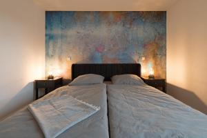 a bedroom with two beds and a painting on the wall at Casa Lorsch 2 in Lorsch