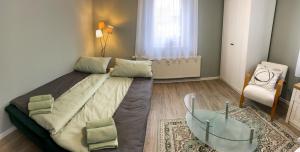 ein Schlafzimmer mit einem großen Bett und einem Stuhl in der Unterkunft Apartment Am Mittelpunkt Deutschlands in Niederdorla