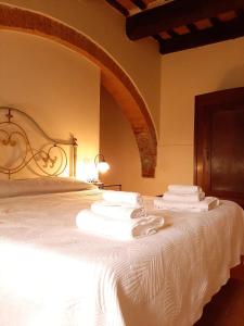 Un dormitorio con una cama blanca con toallas. en agriturismo il Borgo en Cetona