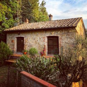una pequeña casa de piedra con 2 ventanas en un jardín en agriturismo il Borgo, en Cetona