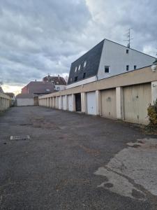 an empty parking lot next to a white building at Petit appart Colmar - ingersheim in Ingersheim +4 photos