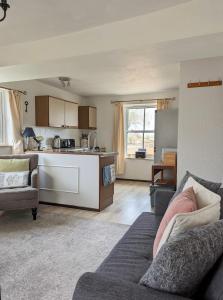ein Wohnzimmer mit einem Sofa und einer Küche in der Unterkunft Humphries Cross Apartments in Rye