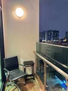 une chaise dans une chambre avec vue sur la ville dans l'établissement Duplex 2 rooms feliz en vista, à Hô-Chi-Minh-Ville