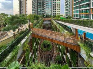 Une passerelle dans une ville avec des arbres et des plantes dans l'établissement Duplex 2 rooms feliz en vista, à Hô-Chi-Minh-Ville