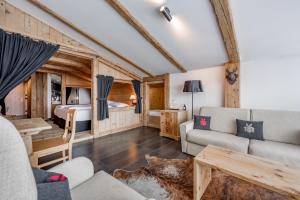 ein Wohnzimmer mit einem Sofa und einem Bett in der Unterkunft Natur & Spa Hotel Lärchenhof in Seefeld in Tirol