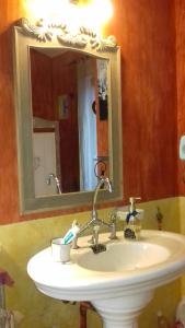 a bathroom with a sink with a mirror and a sink at B&B L'Avelan in La Trinité