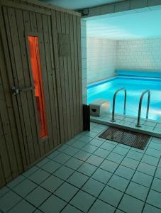 a bathroom with a swimming pool with two faucets at 2 Zimmer Wohnung Pool u. Sauna Zugang möglich 