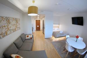 a living room with a couch and a table and a bed at Modern Studio in Prime Location in Vantaa