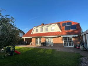 a brick house with a red roof and a yard at 2 Zimmer Wohnung Pool u. Sauna Zugang möglich 