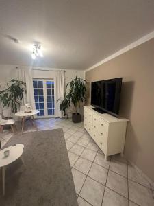 a living room with a flat screen tv and a table at 2 Zimmer Wohnung Pool u. Sauna Zugang möglich 