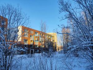 un edificio nella neve di fronte a un edificio di Modern Studio in Prime Location a Vantaa