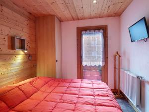 a bedroom with a large red bed in a room at La Ruche RU0494 in La Clusaz