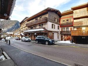 a street with cars parked in front of a building at La Ruche RU0494 in La Clusaz