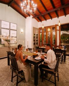 een man en vrouw aan een tafel in een restaurant bij The Weir House in Ulapane