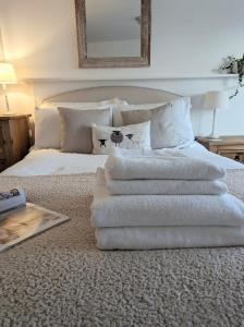 sterta ręczników na łóżku w obiekcie Humphries Cross Apartments w mieście Rye